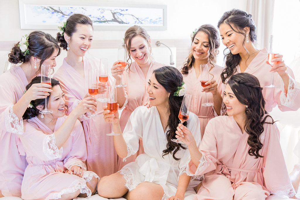 Chelsey and bridesmaids cheers at hotel in pink robes