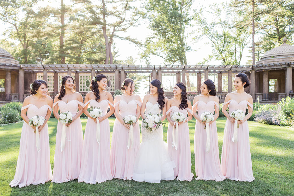 Chelsey and Liangbi bridesmaids wearing pink dresses smiling at each other