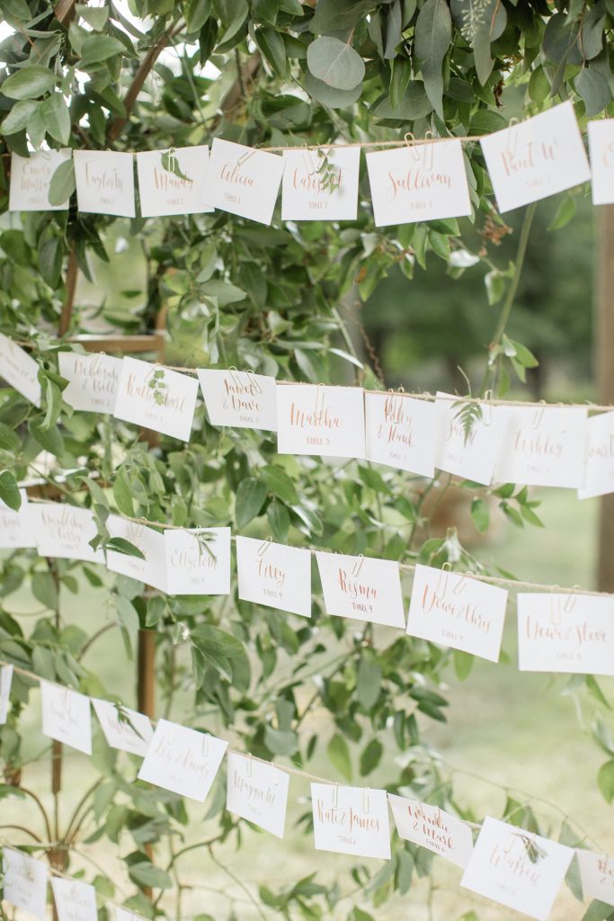 Prita and Mac Twin Lake Village wedding escort cards on strings by the tree