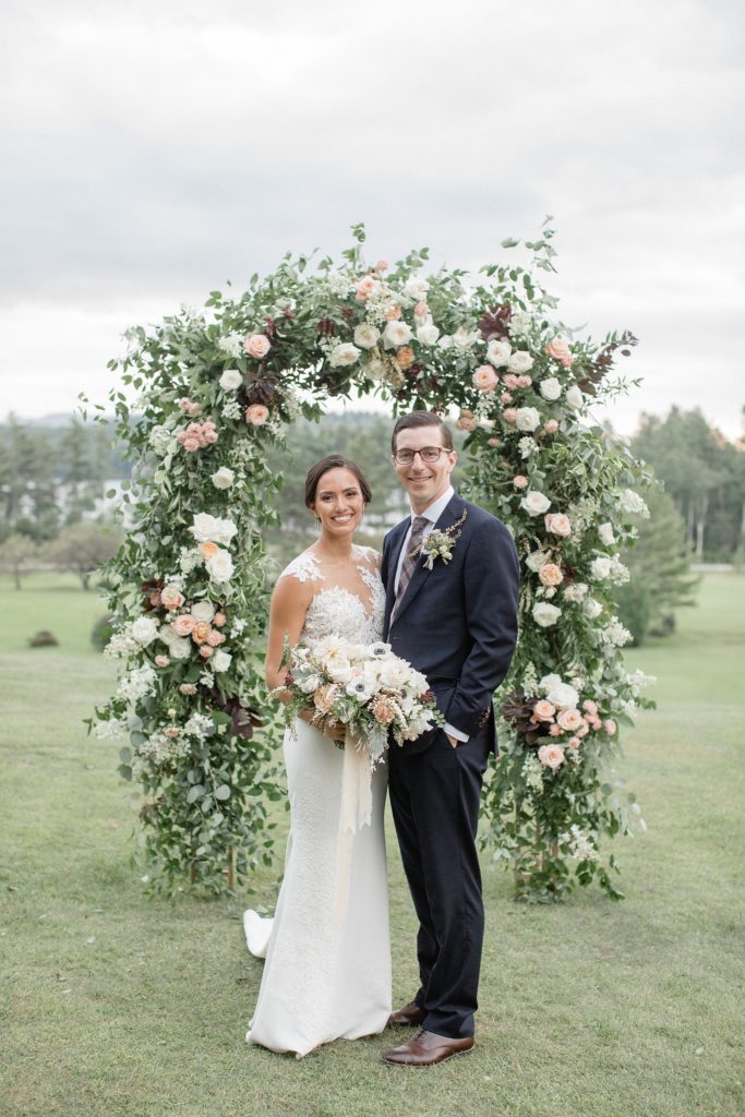 Prita and Mac Twin Lake Village wedding standing next to floral alter